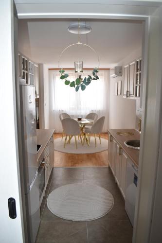 a kitchen with a table and a chandelier at Elite Suites - Vogošća in Vogošća
