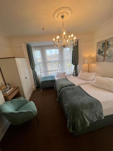 a large bedroom with two beds and a chandelier at A & B Guest House Cambridge in Cambridge