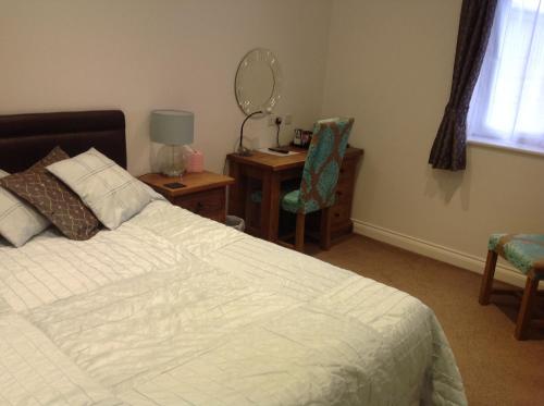 a bedroom with a bed and a desk with a mirror at Crich Lane Farm in Alfreton