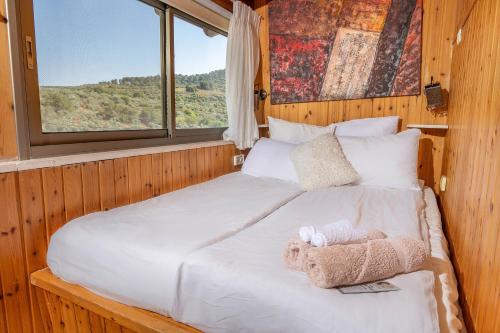a bedroom with a bed with a stuffed animal on it at נוף ארץ הגליל - צימרים מהממים במצפה נטופה in Mitspe Netofa