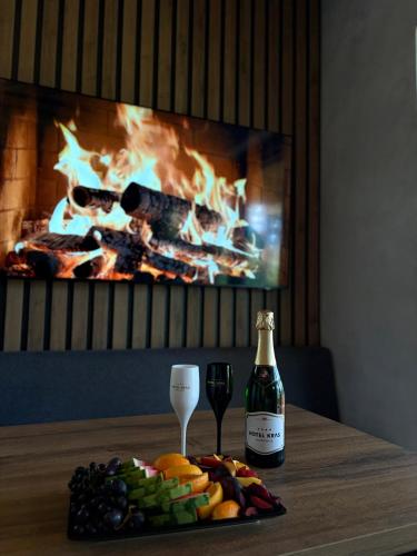 a table with a bottle of wine and a plate of food at Hotel Kras in Jedovnice