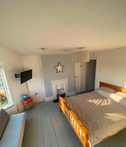 a bedroom with a large bed and a fireplace at Strand Retreat in Tintagel