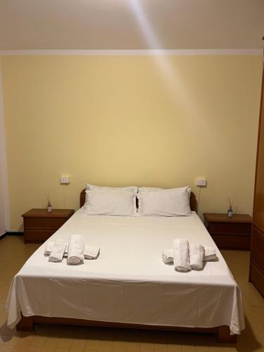 a bedroom with a white bed with towels on it at La casa di RÒ in Avegno