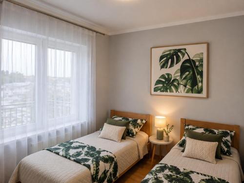 two beds in a room with a window at Apartament Fabryczna Premium TK in Namysłów