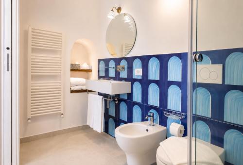 a blue and white bathroom with a toilet and a sink at La Terrazza del Sole a Positano in Positano
