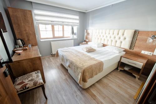 a bedroom with a large white bed and a window at Şehrizade Konakları in Amasya