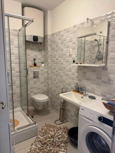 a bathroom with a toilet sink and a washing machine at New apartment Dany with parking for two in Split