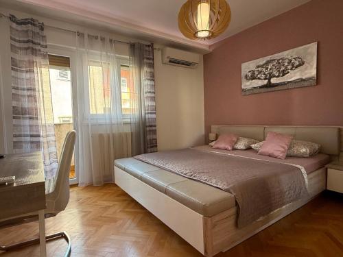 a bedroom with a bed with pink pillows on it at New apartment Dany with parking for two in Split