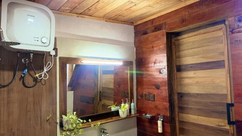 a bathroom with a sink and a mirror and a tv at Glenora Wood Cabin in Ella