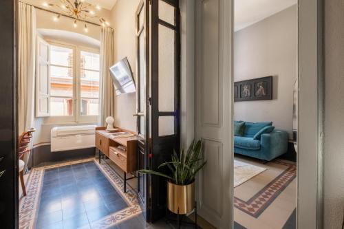 a hallway with a living room with a blue couch at guesthouse Electra in Iglesias