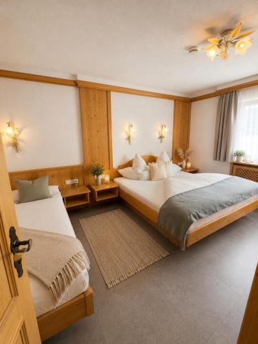 a bedroom with two beds and a window at Haus Alpenecho in Mittelberg