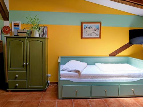 a bedroom with a bed and a green cabinet at Ferien am Schloss - Wohnung 2 "die Maus", Ferienwohnung am Badesee in Behren-Lübchin