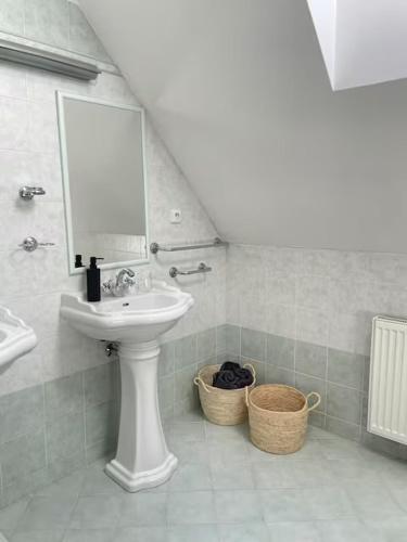 a bathroom with a sink and a mirror and baskets at Prázdninový dům Litomyšl 79 in Litomyšl