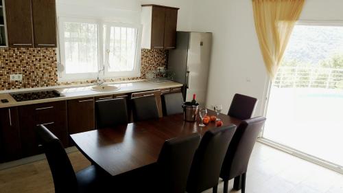a kitchen with a table and chairs and a kitchen with a refrigerator at Yokana Villa & Pool in Virpazar