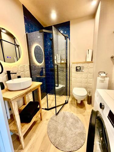 a bathroom with a shower and a sink and a toilet at Freshly Renovated Black & Sand Studio in Liepāja