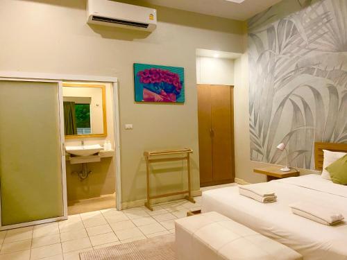 a bedroom with a bed and a bathroom with a sink at Spice & Sea Resort in Kata Beach