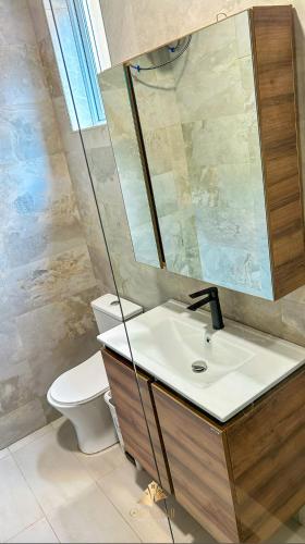 a bathroom with a sink and a toilet and a mirror at ORIGAMI APARTMENTs in Boi
