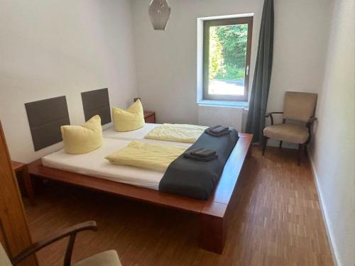 a bedroom with a bed with a chair and a window at Haus Charlottenburg 2, zentrumsnah mit Blick auf die Festung, mit Sauna-Option in Königstein an der Elbe