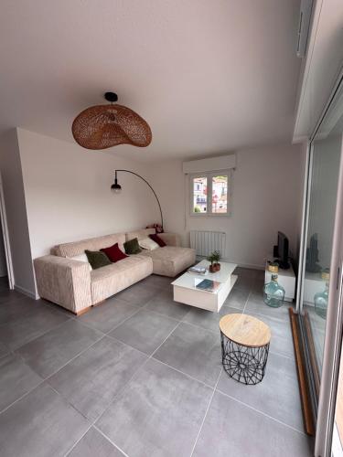 a living room with a couch and a table at Maison a Socoa in Urrugne