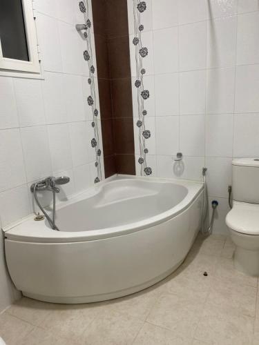 a white bath tub in a bathroom with a toilet at Dar Emna in Hammamet