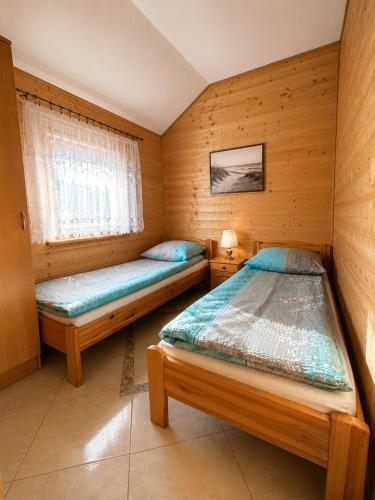 a bedroom with two beds and a window at Domki i Pokoje u Asi in Stegna