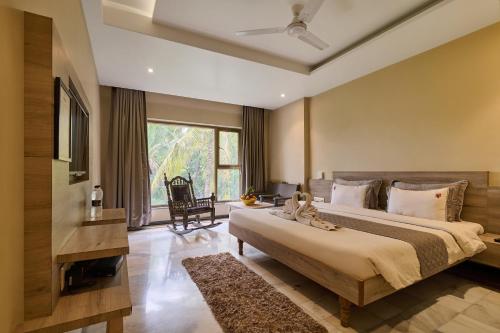 a bedroom with a large bed and a large window at Hotel Hrushikesh in Shirdi