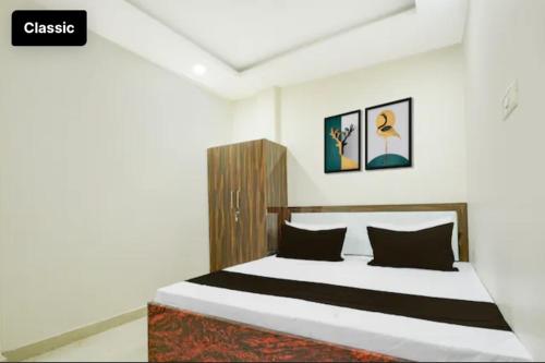 a bedroom with a bed with black and white sheets at Tansen Guest House in Gwalior