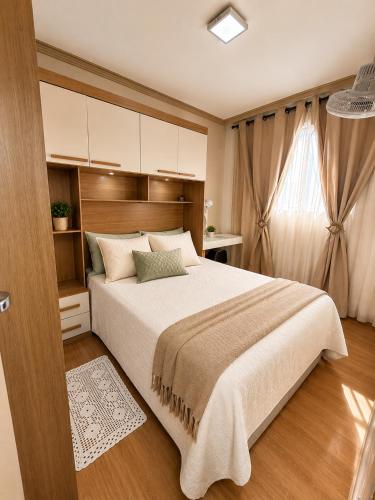 a bedroom with a large bed and a window at Cantinho aconchegante in Londrina