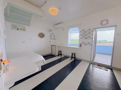 a room with a bed and a desk and a window at 燈塔情人歐風海景民宿 in Eluan