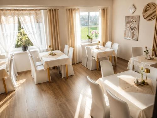 a restaurant with white tables and chairs and a window at Wellness Hotel Staré Město in Uherské Hradiště