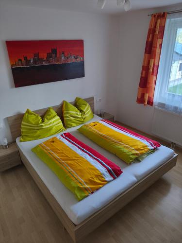 a bed with yellow pillows on it in a room at Putz Appartements in Gröbming