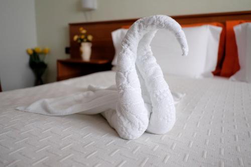 a towel animal is sitting on a bed at Hotel Nais in Durrës