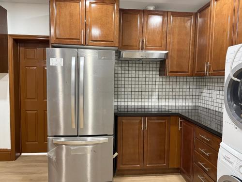 a kitchen with wooden cabinets and a stainless steel refrigerator at Downtown Residance Room 2 in Guelph