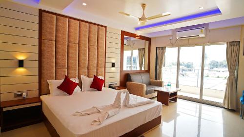 a bedroom with a bed and a chair in a room at ROYAL GITANJALI RESORTS & SPA in Mandarmoni