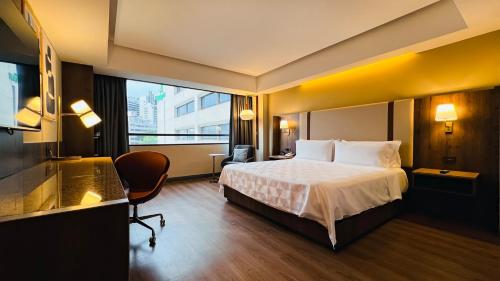 a hotel room with a bed and a large window at Holiday Inn Mexico City-Plaza Universidad by IHG in Mexico City