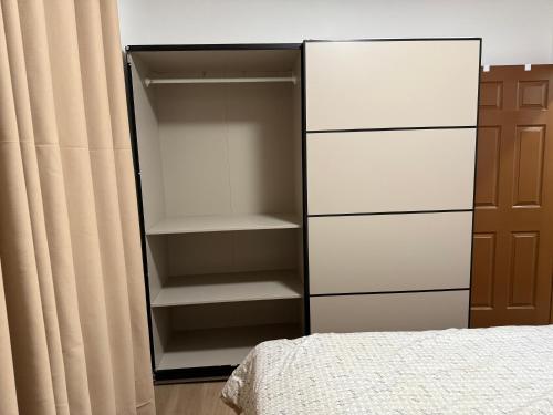 a closet with white shelves and a bed in a room at Downtown Residance Room 2 in Guelph