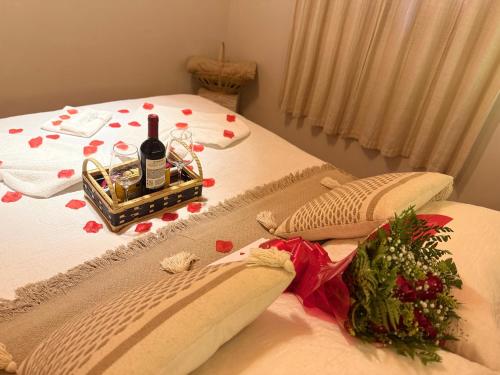 a bed with two bottles of wine and a christmas tree on it at Chalé Recanto do Quilombo - MV in Camanducaia