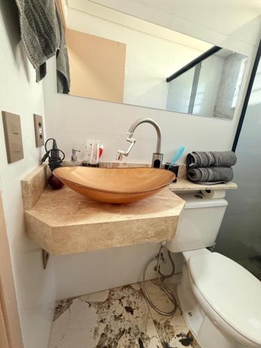 a bathroom with a wooden sink and a toilet at Cantinho aconchegante in Londrina