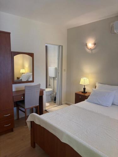 a bedroom with a bed and a desk and a mirror at seafront HOUSE LALA Vinišće in Vinišće