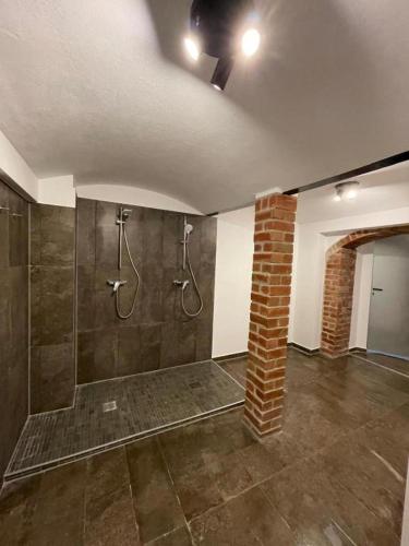 a bathroom with a shower and a brick pillar at Haus Charlottenburg 2, zentrumsnah mit Blick auf die Festung, mit Sauna-Option in Königstein an der Elbe