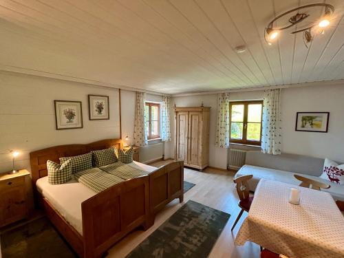 a bedroom with a bed and a couch and a table at Gasthof Kronreith in Maria Alm am Steinernen Meer