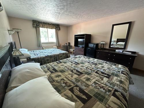 a hotel room with two beds and a mirror at K&G Lodge in Oswego