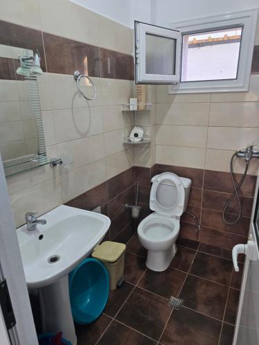 a bathroom with a toilet and a sink at Summer Tale Rooms in Tale