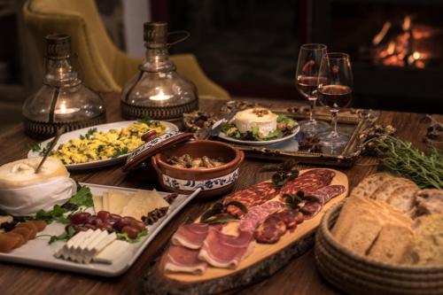 a table topped with plates of food and glasses of wine at Monte do Cardal in Odeceixe