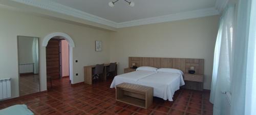 a bedroom with a white bed and a wooden floor at Casa Milor in Cabrafigal