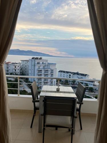 a table and chairs on a balcony with a view of the ocean at Bluemoon Suites Sarande in Sarandë