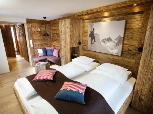 a bedroom with two beds and a table in it at Hotel Alpenfriede in Sölden