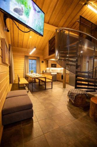 a living room with a television and a room with a couch at Tunturipöllö 3 in Ruka