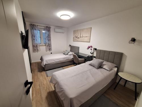 a small bedroom with two beds and a table at Casa Bianca Apartman Dramalj in Dramalj