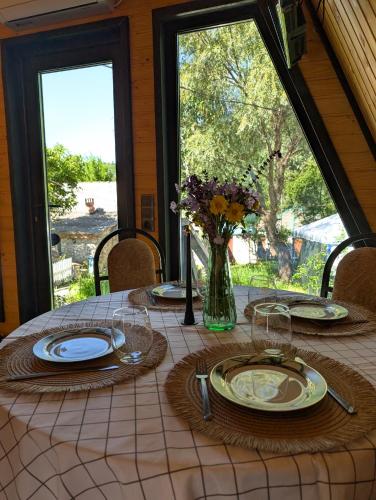 a table with plates and a vase of flowers on it at Hanul Haiducilor in Şendreni